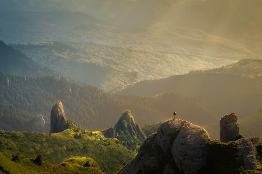 A hiker looking out over mountains in the evening light